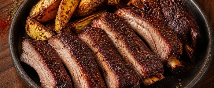 Smokey spareribs met donkere kruidenkorst en aardappelparten